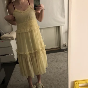 Gul klänning  - Säljer denna gula klänning med ”volanger” och en inner klänning som går till ner över rumpan då den aldrig används, super fin och färgen är mer lik den första bilden än andra (frpga om fler bilder) super skön och v-ringad, justerbara band 