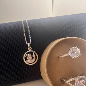 Silver hala band och silver ringar  - Halsbanted med zodiac sign vattenmanen  e 925 K sliver har köpts i guld fynd skulle vilja ha 350kr  för den , e inte säker p ringarna men dom e ganska stora borde passa p flera personer 300 kr st originellt i butiken kostade dom 399 st .