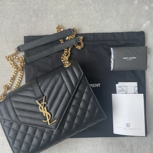Ysl - Säljer min Saint laurent envelope medium bag. (Svart med gulddetaljer) Väskan är i nyskick, knappt använd. Kvitto, dustbag och taggar medföljer.  Nu pris i butik: 25.274 Mitt pris: 18.000  Mer bilder kan skickas 
