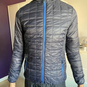 Cutter & Buck jacka  - En extravagant utomhus jacka byggd på ett stark material som är otroligt lightweight. Dessignad för att framhäva en lättnad av rörelse och skyddar mot regna och vind. Håller dig varm året om. Helt ny och oanvänd med lappar kvar. Nypris 2900kr. 