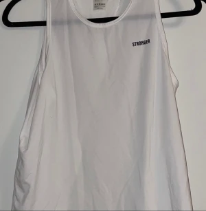 Tränings Linne - Ett vitt linne från STRONGER med öppen rygg, säljer även en likadan fast svart. Nypris 299kr. Köparen står för frakten, pris kan diskuteras.