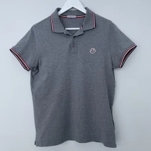 Moncler piké  - Moncler piké  Storlek: S Skick: 9/10 (nyskick med kvitto) Färg: grå Vårt pris: 1300kr Retail: 2500kr