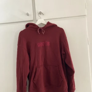 Vinröd hoodie - Hoodie i superfin vinröd färg med subtilt tryck på bröstet. Storlek XS men från herravdelningen så passar mer som en S eller liten M som tjej.