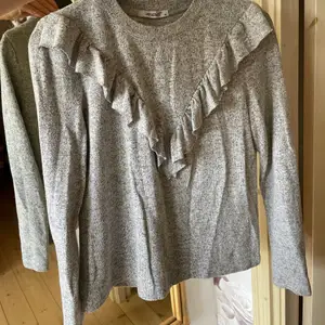 Jättefin långärmad grå tröja med volang på framsidan i gott skick. Storlek M men är liten i storleken, den är mer en XS-S. Skriv gärna för frågor eller fler bilder!💗