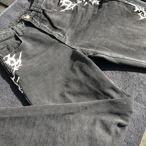 Svarta jeans  - Svarta jeans med taggtråds tryck på sidan av benen