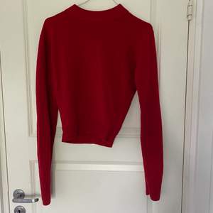 En röd stickad tröja. Vet inte vad märket är men sen är jättefint. Inte alls ett material som kliar.