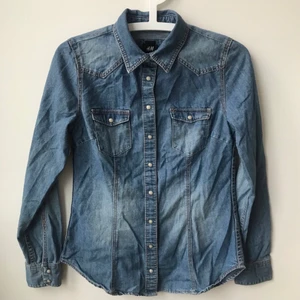 Jeansskjorta med bröstfickor, storlek 34 - Jeansskjorta i fint skick, storlek 34. Bomull- och polyesterblandning. 