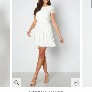 Camellia Lace Dress White, size 36 - En otroligt söt och fin festklänning som inte har använts mer än en gång, söker nu en ny ägare. Klänningen har en vacker spetsdetalj i ryggen. Det ursprungliga priset ligger idag på 899kr på Bubblerrom. Klänningen är bra i passformen. 