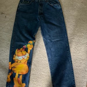 Jeans Garfield - Katten e handmålad, dock bra gjord. Går att tvätta färgen går ej bort. Använda en gång.