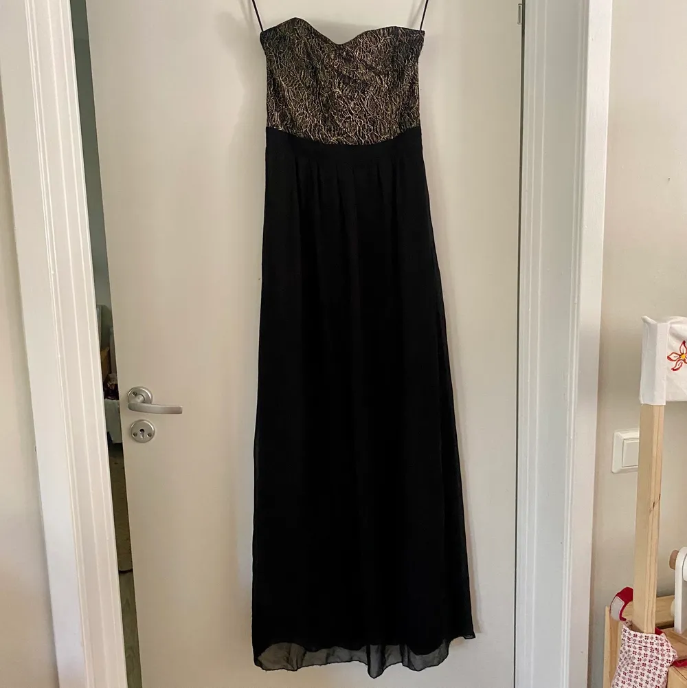 Vacker svart klänning med gulddetaljer, endast använd 2ggr. . Klänningar.