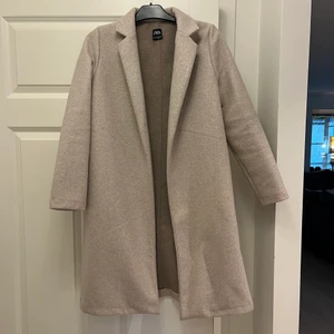 Biege kappa - Jättefin biege kappa frpn zara, helt perfekt nu till hösten. Använd fåtal gånger och sparsamt använd så den är i nyskick. Storlek M men passar även en S.