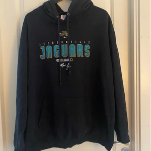 NFL oversize jaguars hoodie strl L - Vintage svart hoodie från NFL.  Jacksonville Jaguars märke på framsidan. Storlek L. Använd ett flertal gånger men i bra skick.  (Köparen står för frakt) 