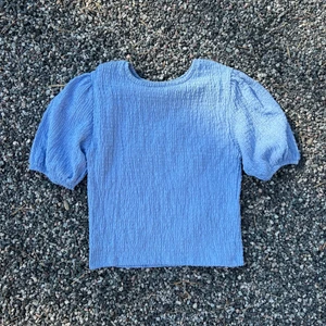 Ljusblå topp med puffärmar - Ljusblå topp med puffärmar från Pull&Bear i stl M. 