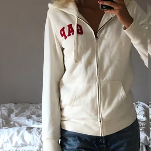 Vit GAP hoodie - Jöttemysig vit GAP hoodie med röd text på. Har fluff överallt utom vid armarna. Bra skick. Passar strl 34, 36 och 38. Skriv privat om intresserad❤️