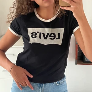Svart levis T-shirt  - En svart T-shirt med vita detaljer från Levis i en kortare modell. 