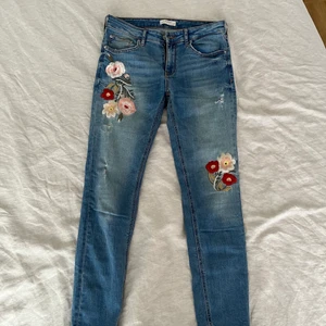 Jeans med broderade blommor - Stretchiga sköna jeans med brodyr i fram. Medelhög midja, normal längd. Passar en storlek m.