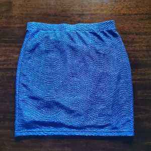 Säljer en blå glittrig kjol i storlek XS då den ej kommer till användning 😊 midjehög.  Köparen står för frakt men kan annars mötas upp kring Solna eller Stockholm 🎉