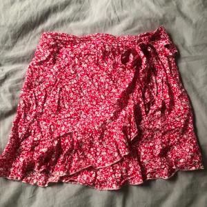 Kjol - Superfin röd kjol med vita blommor på. 