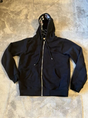 Svart Burberry hoodie - Säljer min Burberry hoodie eftersom den inte passar längre. Endast använt ett fåtal gånger. Det står L på den men den passar som M. Ställ frågor ifall ni undrar nåt. Priset kan såklart diskuteras vid snabb affär. 