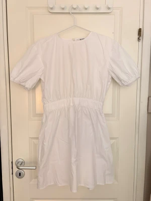 Klänning med öppen rygg - Vit mini bomulls klänning med öppen rygg Otroligt fin - perfekt till vardags eller student/avslutningsklänning Använt 1 gång