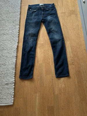 Mörkblå slim fit jeans - Snygga mörkblå slim fit jeans med klassisk femficksdesign och subtila slitningar på låren. Jeansen har raka ben och är tillverkade i ett mjukt denimtyg som ger en skön passform. Perfekta för en avslappnad och trendig look. Priset kan diskuteras, kom med förslag, passar även 30 längd och 28 i midjan, 