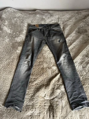 Grå dondup jeans - Säljer ett par grå slim jeans med slitningar från dondup, få defekter men utöver detta så är de fint skick. Är 180 cm lång och upplever att de har en bra passform. W30 L30.