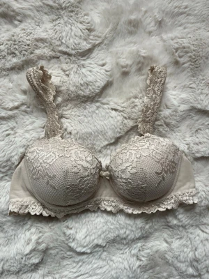 Intimissimi bh - Säljer en beige bh med vadderade kupor och vacker spetsdetalj över hela framsidan och axelbanden. Bh:n har dekorativ spetskant nedtill och breda axelband för extra komfort. Perfekt för dig som gillar romantisk och feminin stil. Intimissimi pretty flowers ej push up🩷