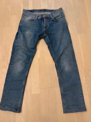 Blå jeans från Nudie Jeans grim Tim  - Säljer ett par tvär feta nudie jeans I grim Tim modell dom är sydda till min längd och jag är 176 cm lång och 69kg 