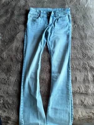 Ljusblå bootcut jeans med dubbla knappar - Säljer ett par ljusblå bootcut jeans från hm. Knappt använda 