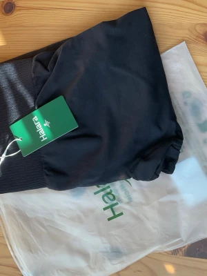 Svarta träningstights från Halara - Säljer ett par svarta seamless byxor från Halara. De har bred ribbad midja och är gjorda i ett mjukt, stretchigt kvalitets material som sitter tajt och bekvämt. Enkel och stilren design. Med tummy control och butt lifting teknologi. De här kommer hålla med länge 