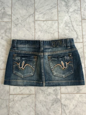 Jeanskjol - Jeanskjol köpt second hand. Märke Joansy Jeans, storlek M (passar också S). Coola detaljer! Mått 40 cm och 26 cm (sista längd).