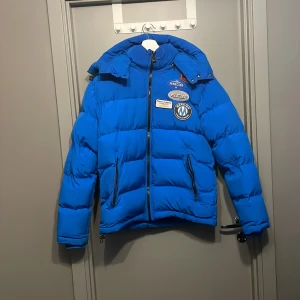 Blå pufferjacka från Mercier med patchar - Tja säljer nu min jacka för den är för stor och använt den några gånger det är storlek m.Tveka inte på att skriva vid funderingar?