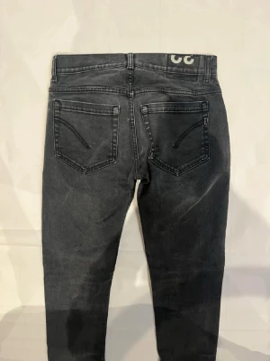 Svarta skinny jeans från dondup  - Snygga svarta skinny jeans från dondup med klassisk femficksdesign och diskret logga bak i midjan. Jeansen har en tvättad look och smal passform som sitter tajt hela vägen ner. Perfekta för en trendig och avslappnad stil. OBS, möts bara upp i Stockholm skickar inte paket via postnord o så vidare😁