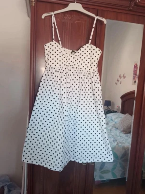 Vit prickig klänning med smala band - Söt vit klänning med svarta prickar och tunna axelband. K