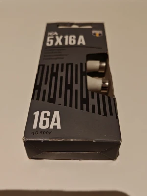 Säkringar 5x16A ICA gG 500V - Förpackning med fem vita säkringar från ICA, modell 16A gG 500V. Passar till elinstallationer och elsystem där 16A säkringar krävs. Kommer i en svart och grå kartong med tydlig märkning. Perfekt för dig som behöver extra säkringar hemma.