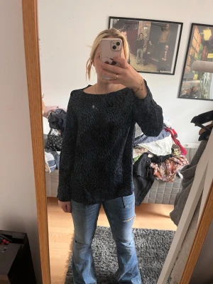 Mörkblå mönstrad blus - Snygg mörkblå blus med diskret svart mönster. Blusen har rund halsringning och långa ärmar. Passar perfekt till jeans för en avslappnad men ändå stilren look. Materialet känns mjukt och följsamt.