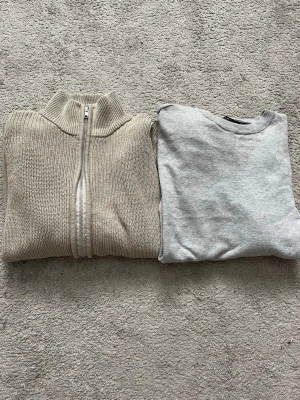 Paketpris, beige ribbstickad ziptröja - Säljer en beige ribbstickad tröja med dragkedja framtill och hög krage. Tröjan har en clean look och är perfekt för lager-på-lager. Materialet är tjockt och mjukt, vilket gör den riktigt skön att bära. Passar dig som gillar minimalistisk stil.