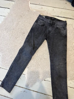 Replay jeans  - Snygga gråa jeans från Replay i modellen Anbass. som har en tvättad look och är tillverkade i stretchigt denimtyg för extra komfort. Perfekta till en avslappnad streetstyle. Storlek: 29/30