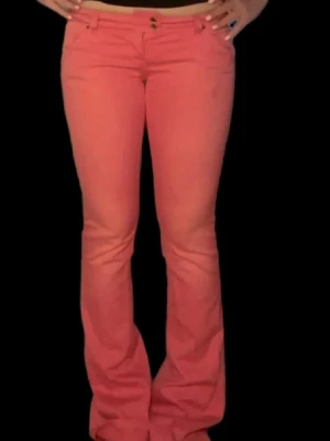 Lågmidjade korall/rosa bootcut jeans - Unika korall/rosa vintage lågmidjade bootcut jeans. Sååå så snygga och coola, säljer bara eftersom jag har ett till par. Perfekt färg nu till våren/sommaren!!!!