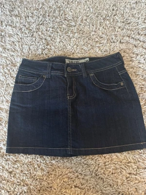 Mörkblå jeanskjol från Sublevel - Snygg mörkblå jeanskjol från Sublevel med klassisk femficksdesign och kontrastsömmar. Mått: Midjemått tvärs över knappen 39cm. Från knappen till enden av kjolen 30cm. Sidan längst uppe ned 33cm. Hör av dig om du är intresserad eller har några frågor❤️