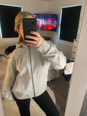 Ljusgrå zip hoodie med huva - En stilren ljusgrå hoodie med dragkedja framtill och två stora fickor. Endast testad och därför i nyskick😊