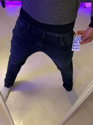 Mörkblå skinny jeans Jack & Jones - Säljer ett par mörkblå skinny jeans från Jack & Jones med klassisk femficksmodell och stretchigt material. Jeansen har en låg midja och smal passform hela vägen ner. Perfekta för dig som gillar en modern och tajt look. 