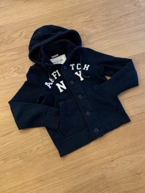 Abercrombie & Fitch cardigan - Säljer en sjukt snygg Abercrombie & Fitch Cardigan. Denna är sjukt eftertraktad och väldigt grisch och archive. Storleken är S. Skicket 10/10. Priset kommer vara 999kr men kan sänkas.