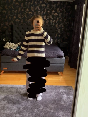 Randig stickad tröja i blått och vitt - Snygg stickad tröja med breda marinblå och vita ränder. Tröjan har rund halsringning, långa ärmar och är ribbstickad för en skön passform. Perfekt för en avslappnad och trendig look.