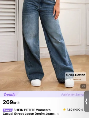 Blå loose fit jeans från SHEIN - Säljer ett par blå loose fit jeans från SHEIN med hög midja och vida ben. Jeansen är tillverkade i bomull och har klassisk femficksdesign. Perfekta för en avslappnad och trendig look. Aldrig använda.
