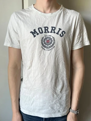 Vit Morris T-shirt - Säljer denna feta vintage t-shirten från Morris. Bra skick, lite skrynklig från tvätt men går bort om man stryker den. Storlek M, modellen på bilden är 184 cm och väger 68kg. Skriv vid funderingar eller frågor! // Oskar, Douceur