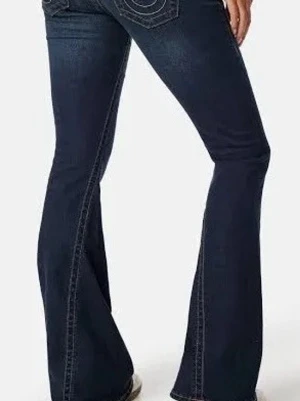 Mörkblå bootcut jeans med kontrastsömmar - PRIS KAN DISKUTERAS!!Snygga mörkblå bootcut jeans med kontrastsömmar och klassiska bakfickor. Jeansen har en utsvängd passform från knät och ner, vilket ger en retrovibe. Tillverkade i denim med stretch för extra komfort.
