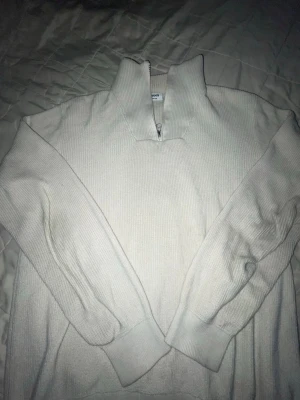 Vit ribbstickad half zip-tröja Kappahl - Snygg vit ribbstickad tröja från Kappahl med half zip-dragkedja i halsen. Tröjan har lång ärm, hög krage och är perfekt för en chill och stilren look. Passar dig som gillar enkel och klassisk stil.
