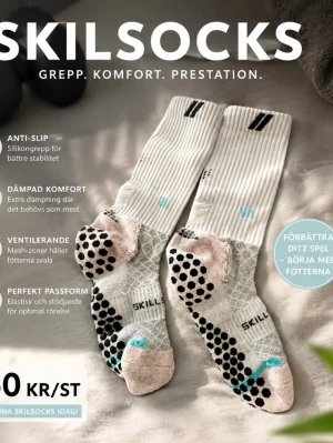 Vita sportstrumpor från Skilsocks - Vita sportstrumpor från Skilsocks med svarta och turkosa detaljer. Strumporna har silikonprickar under foten för extra grepp, mesh-zoner för ventilation och elastisk passform. Perfekta för dig som vill ha stabilitet och komfort under träning.