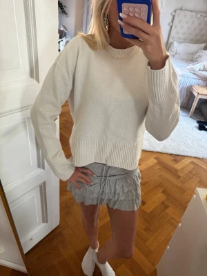 Vit stickad tröja från & Other Stories - Snygg vit stickad tröja från & Other Stories med rund halsringning och ribbade muddar vid ärmslut och nederkant. Enkel och stilren design som passar perfekt till många outfits. Tröjan är mjuk och skön, tillverkad i en blandning av ull och nylon.